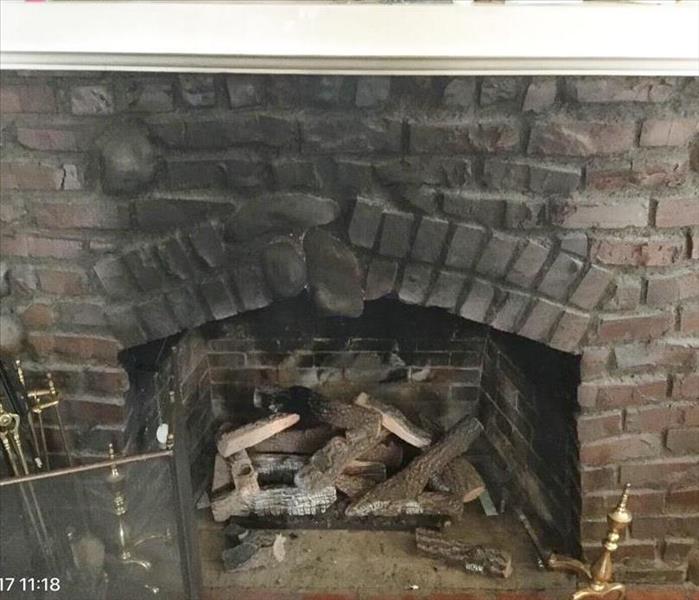 Dark brick fireplace with heavy black soot